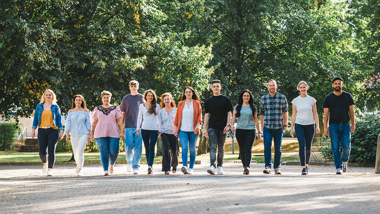 Gruppe von jungen Menschen läuft nebeneinander im Grünen