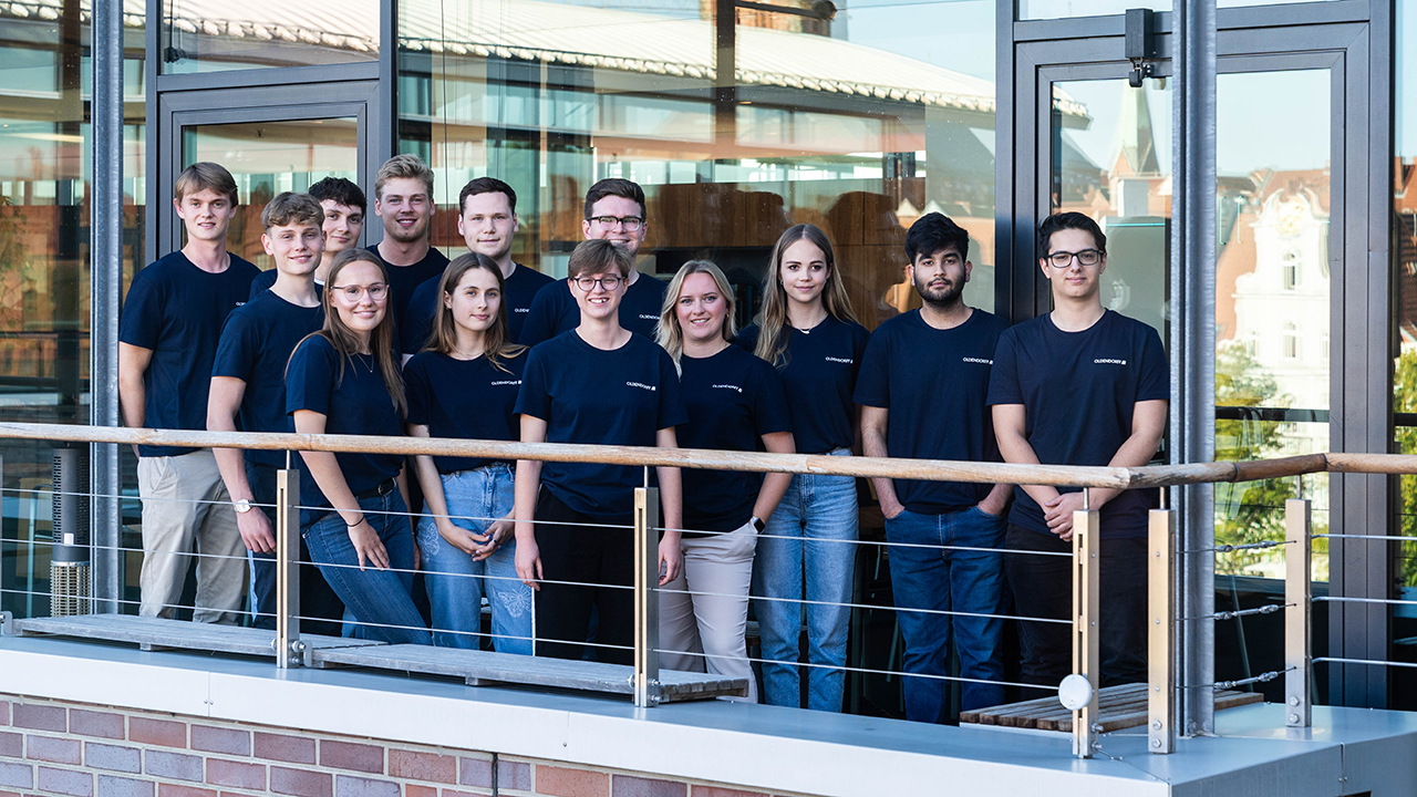 Mitarbeitergruppe steht auf einem Balkon