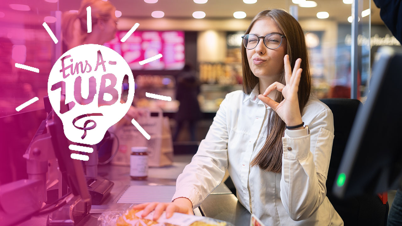 Person zeigt das Okay-Zeichen und sieht in die Kamera. Linksseitig sieht man eine stilisierte Glühbirne mit der Innenschrift "Eins A-ZUBI".