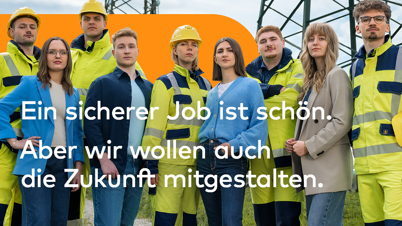 Personengruppe, teilweise mit Arbeitskleidung und Helm.
