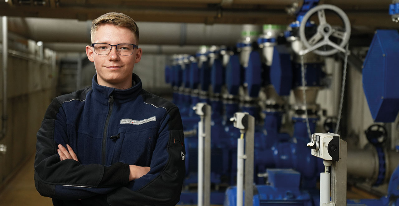 Junger Mensch, steht vor Röhrensystem