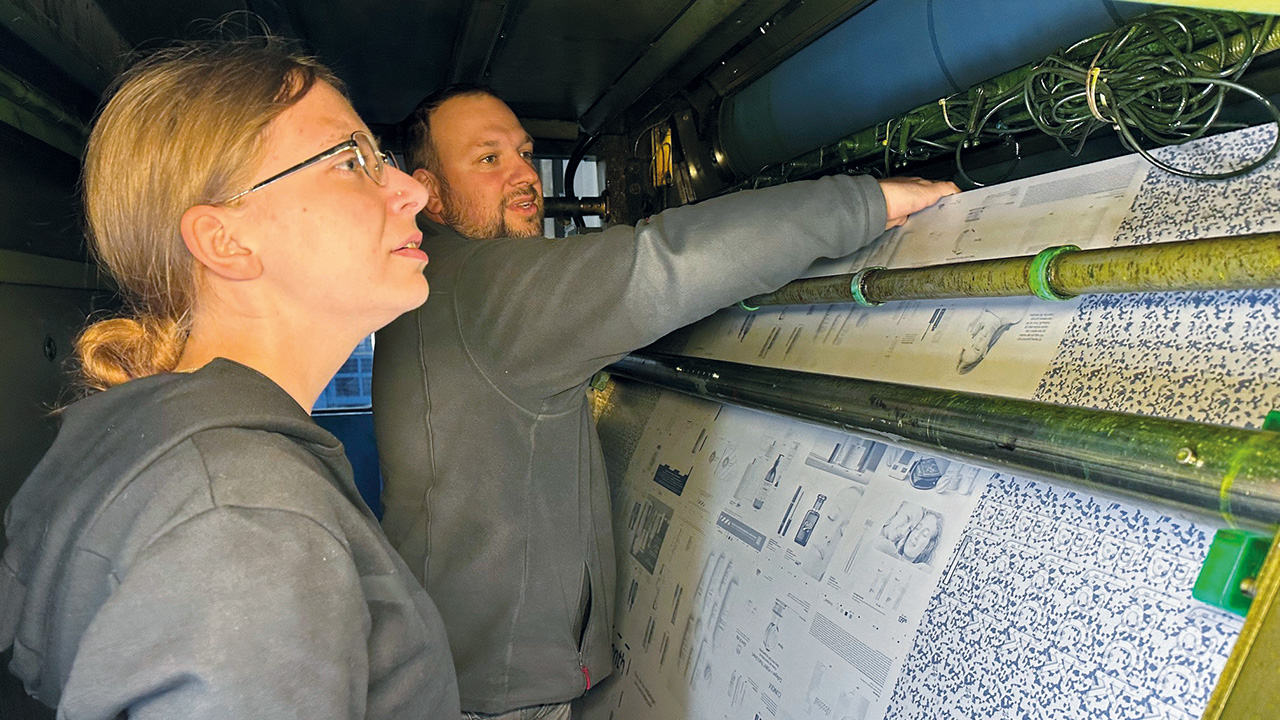Zwei Mitarbeitende an der Druckmaschine