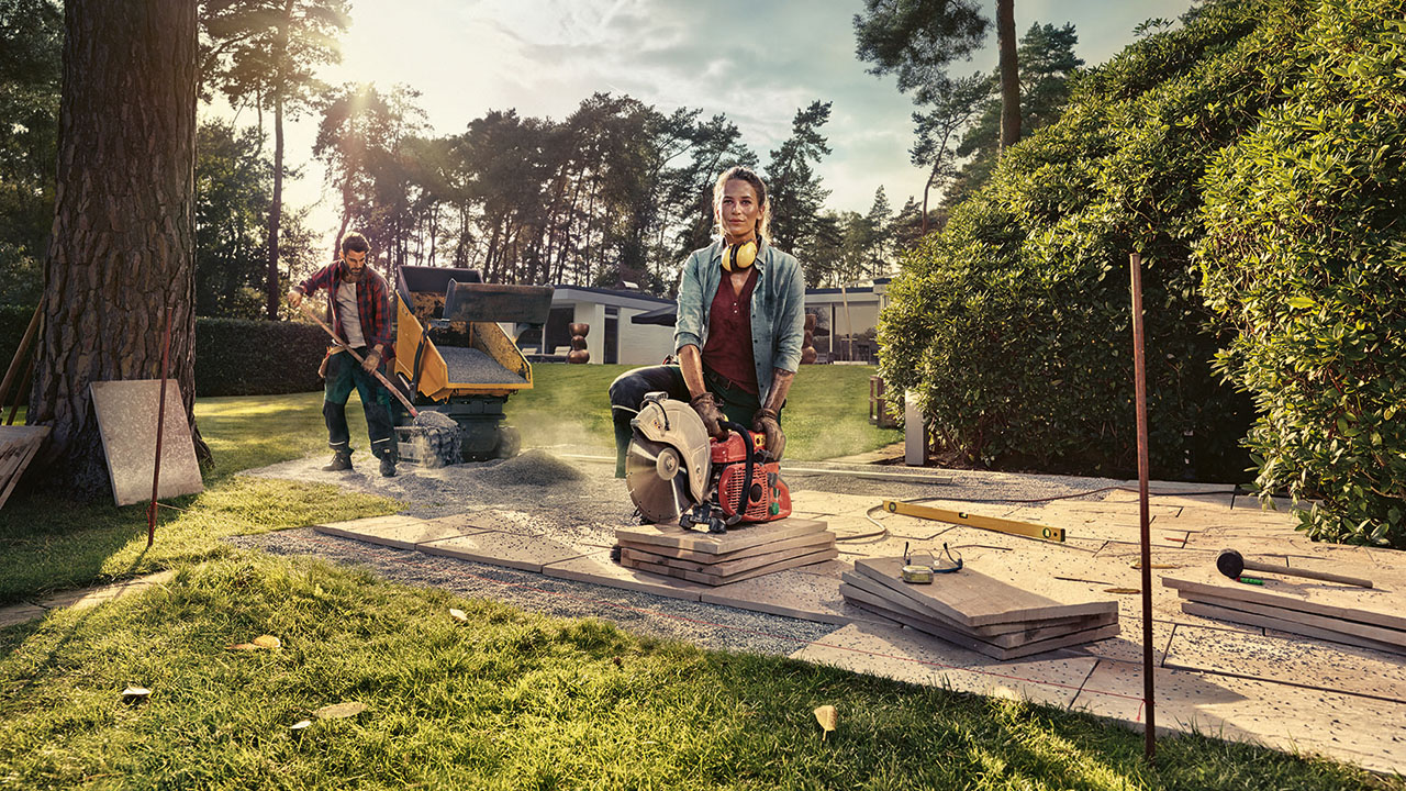 Zwei Landschaftsgärtner beim Verlegen von Fliesen in einem großen Garten