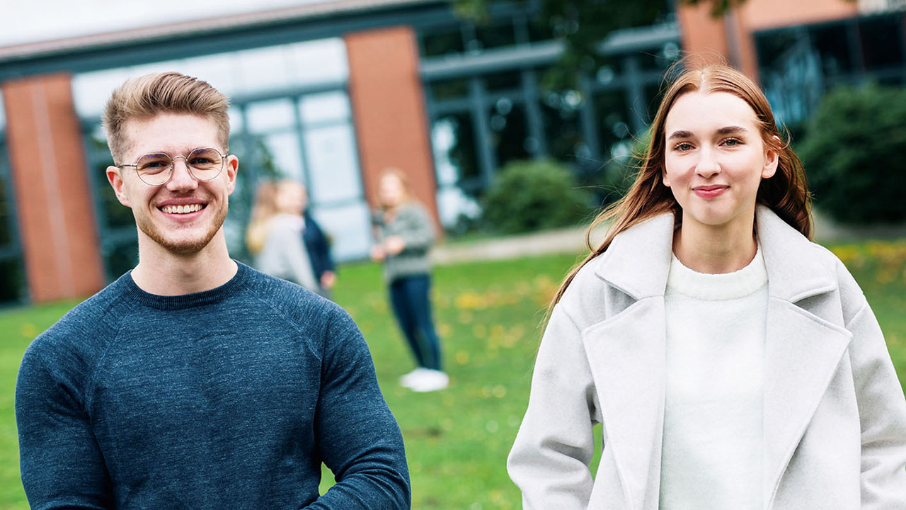 Zwei junge Menschen lächeln in die Kamera