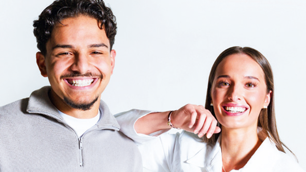 Junger Mann und junge Frau die in die Kamera lächeln.