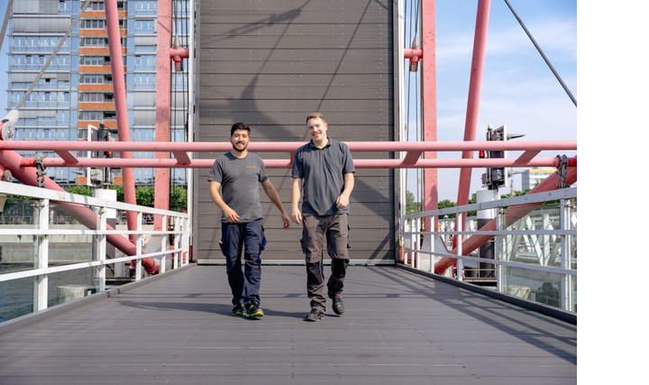 Zwei Mitarbeitende auf einer Brücke