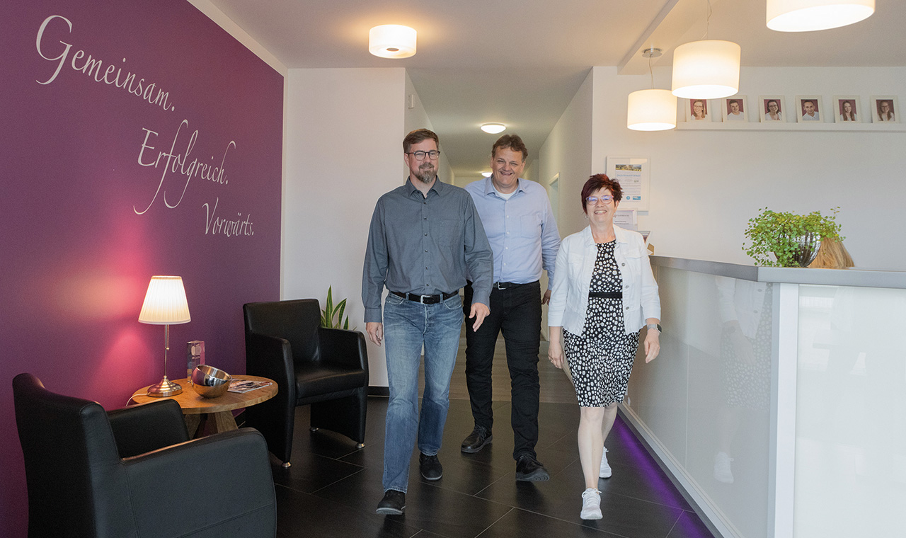 3 Miatarbeiter/innen in der Kanzlei, lächeln in die Kamera