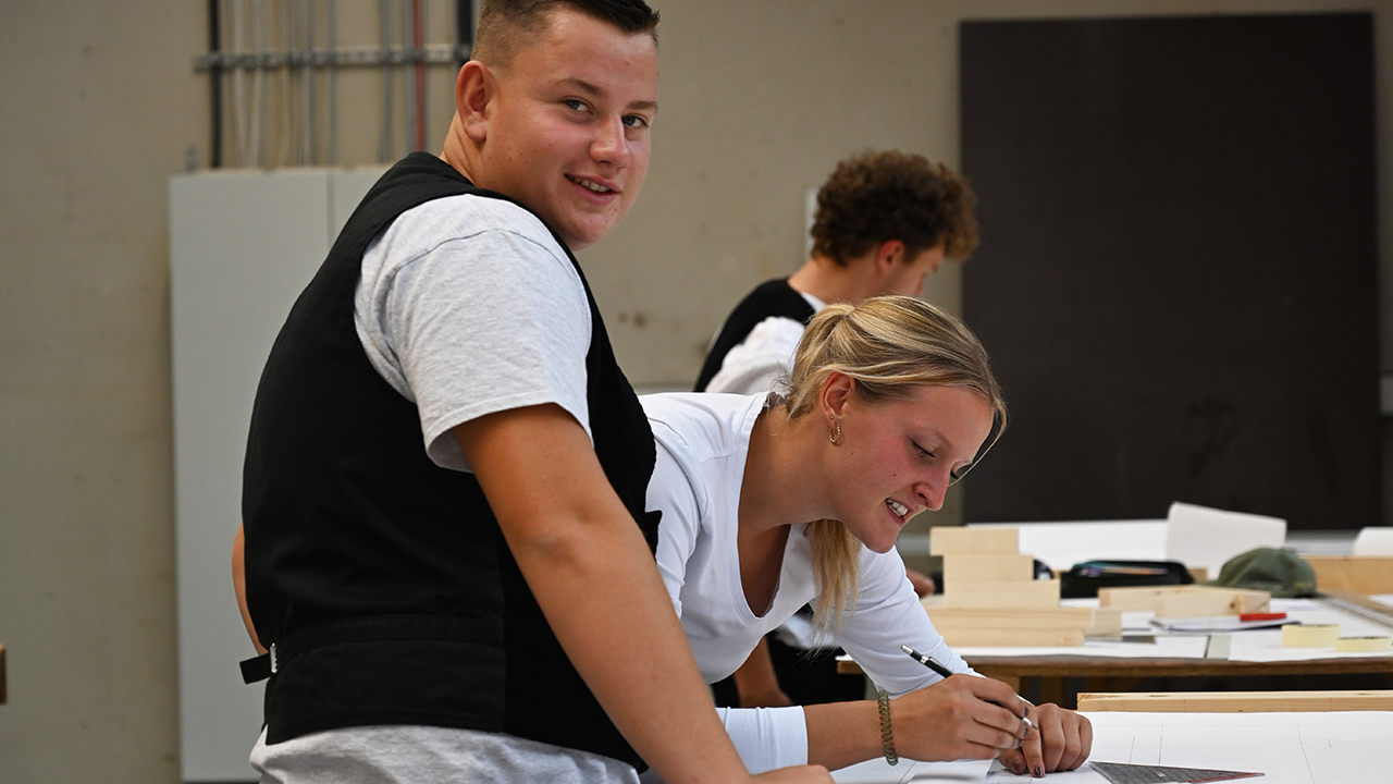 Zwei Auszubildende die an einer Zeichnung arbeiten.