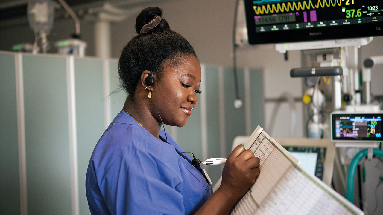 junge Frau notiert Messwerte von klinischen Geräten