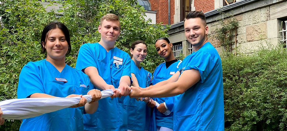 Azubis ziehen gemeinsam an einem Tuch