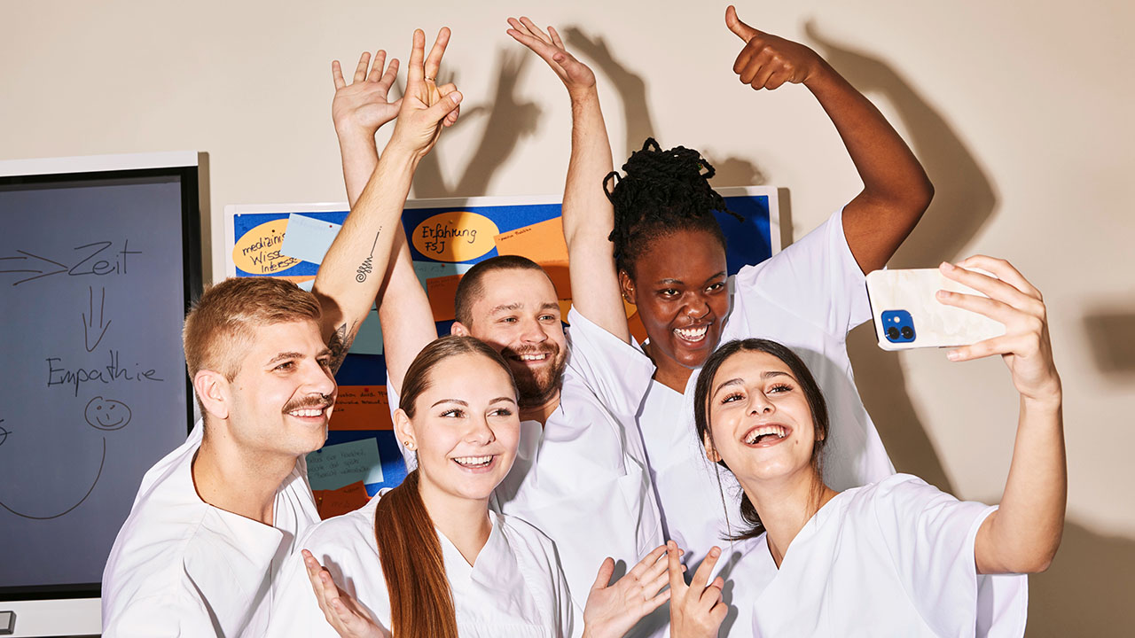 Selfie von jungen Menschen in weißer Pflegebekleidung