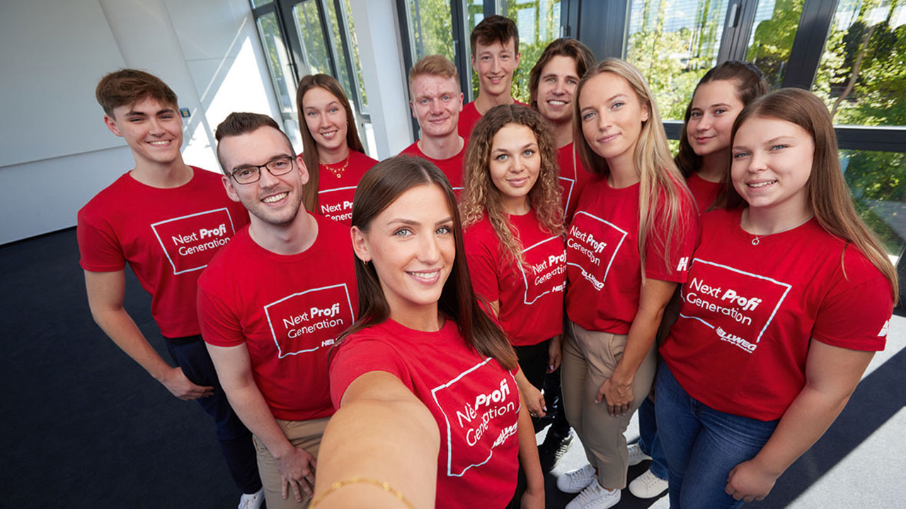 Gruppenfoto von elf Auszubildenden in roten T-Shirts mit der Aufschrift: Next Profi Generation