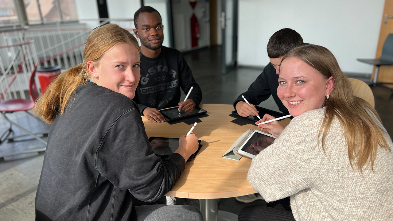 Schülergruppe mit Tablets an einem Tisch