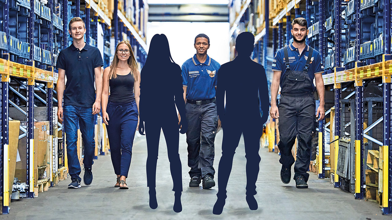 Vier junge lächelnde Personen in einer Lagerhalle, dazu zwei Umrisse von Personen als Plathalter für neue Auszubildende
