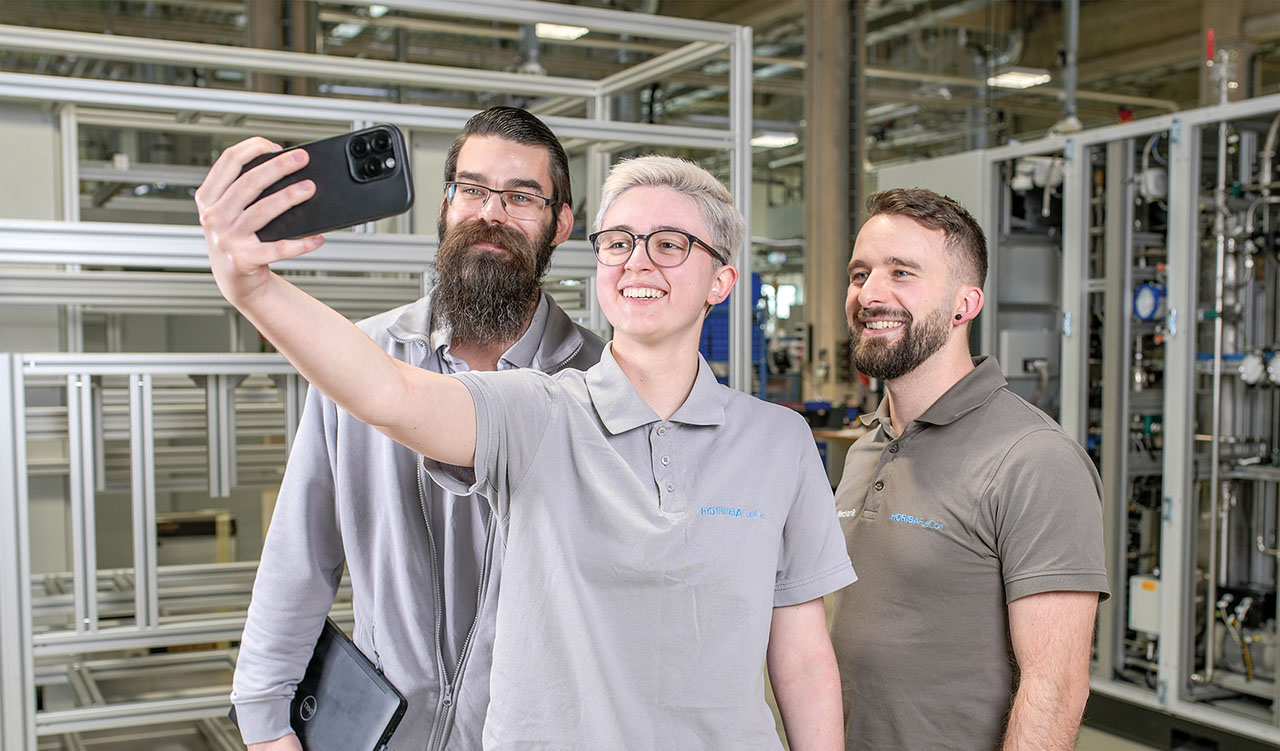 Drei freundliche Personen werden beim Selfie machen fotografiert.