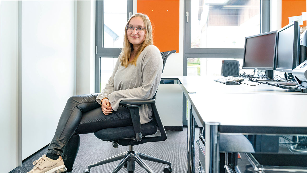 Person auf Bürostuhl am Schreibtisch