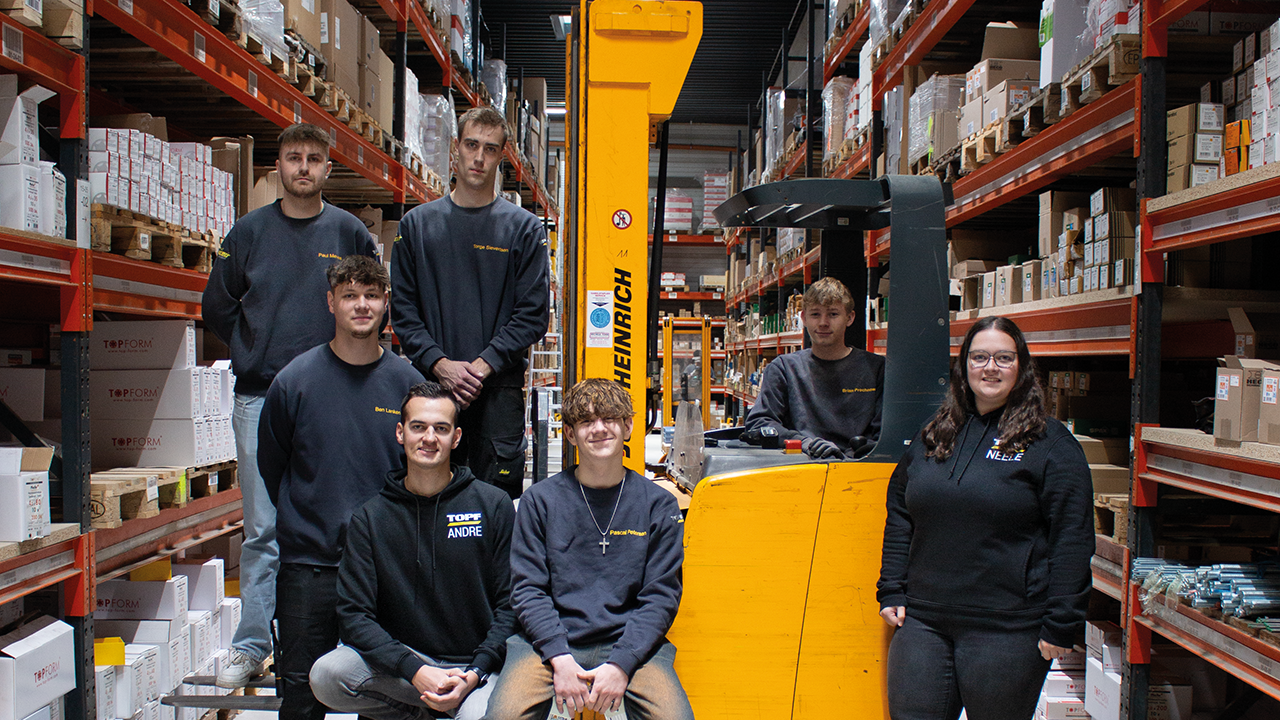 Eine Gruppe junger Menschen in einer Lager Halle, sitzend auf einem Gabelstabler