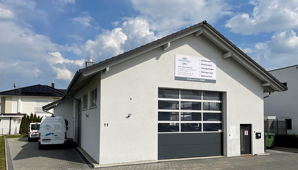 Das Gebäude der Kälte- Klima Dennis Merk GmbH & Co. KG bei blauem Himmel mit weißen Wolken