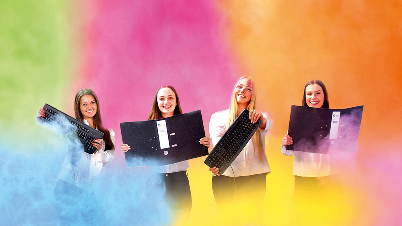 Vier junge lächelnde Personen mit Aktenordnern und Tastaturen in der Hand vor einem bunten Hintergrund