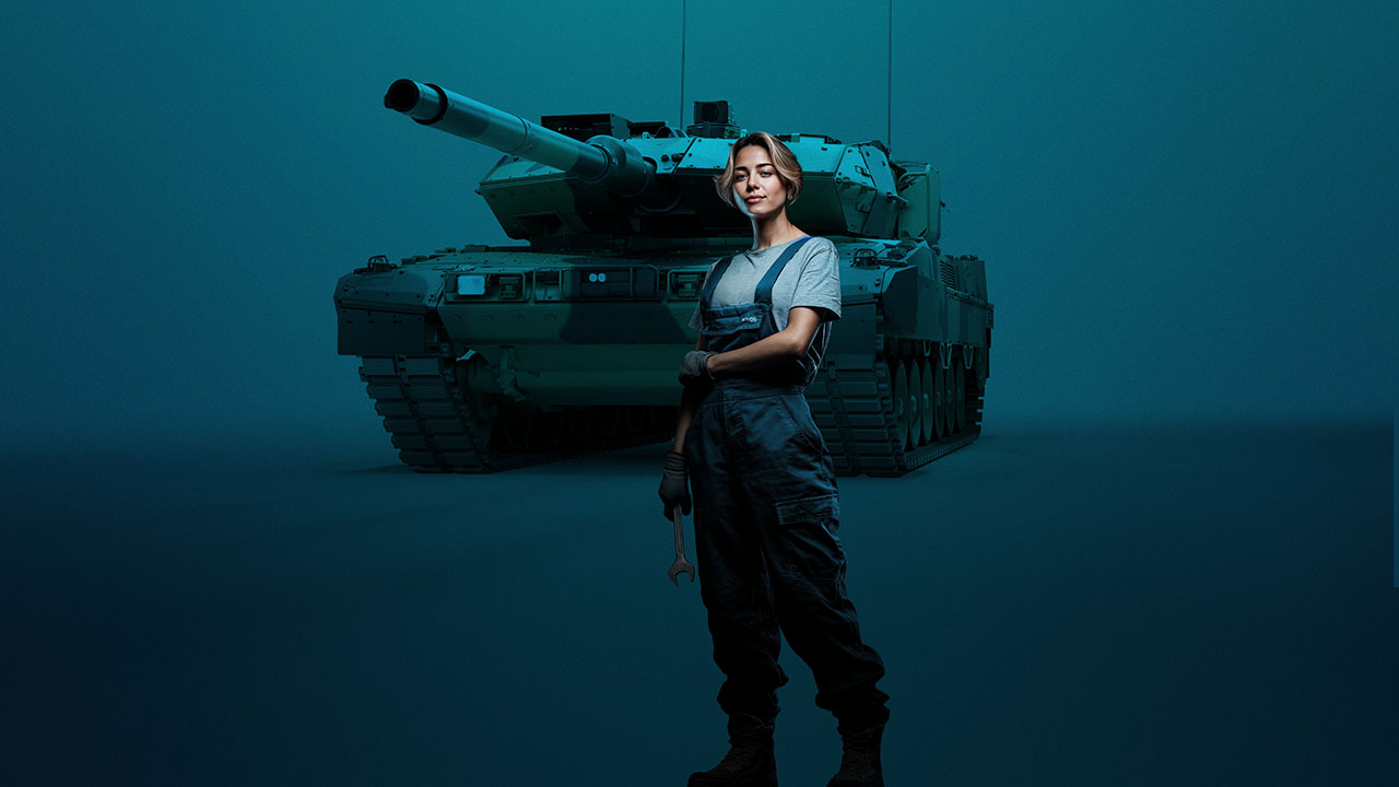 Person in Arbeitskleidung vor Panzer