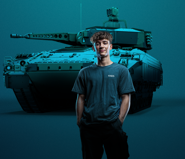 Junger Mann steht vor einem Panzer