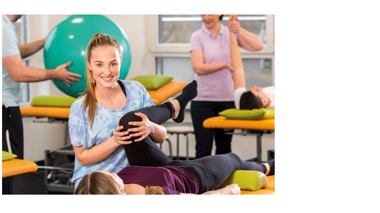 Mehrere Personen führen physiotherapeutische Übungen auf Behandlungsliegen durch.