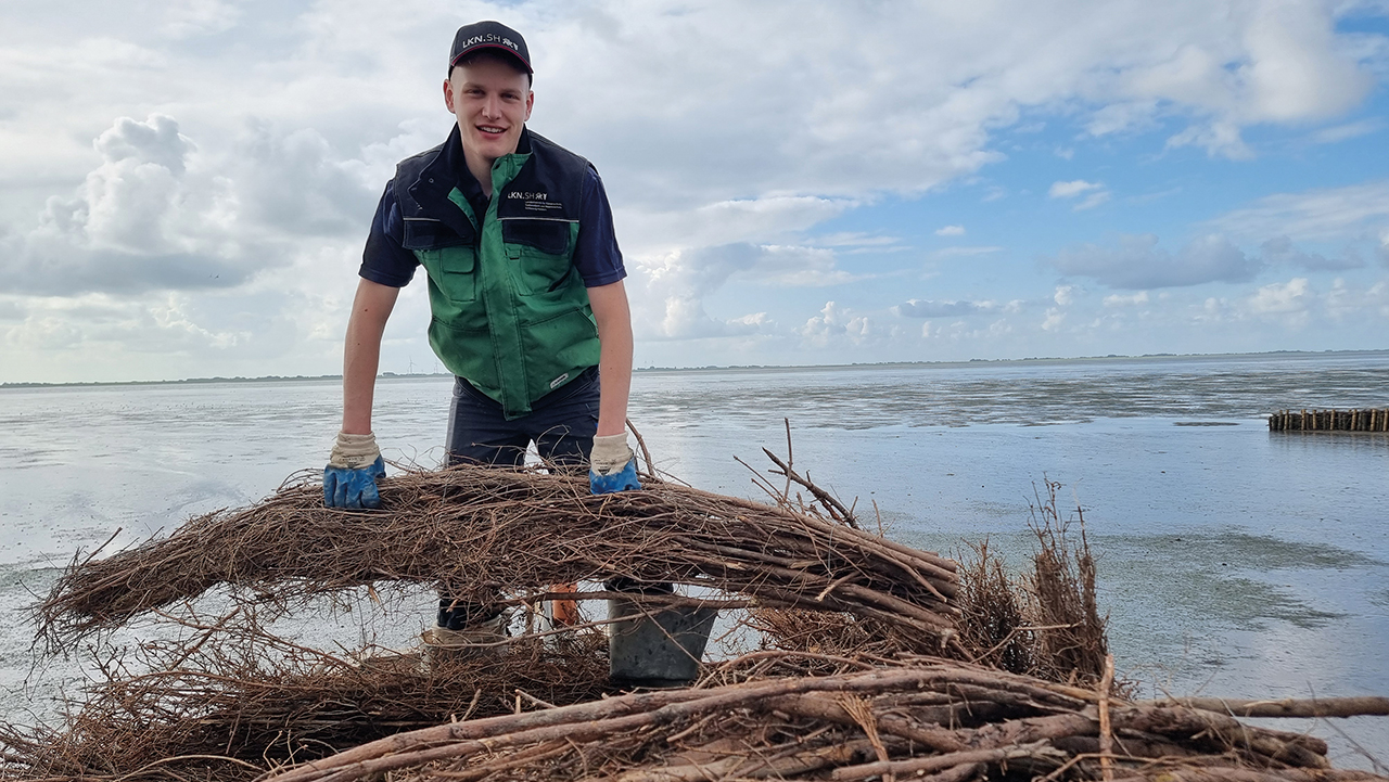 Junger Mann in Wasserschutzkleidung im Meer arbeitend