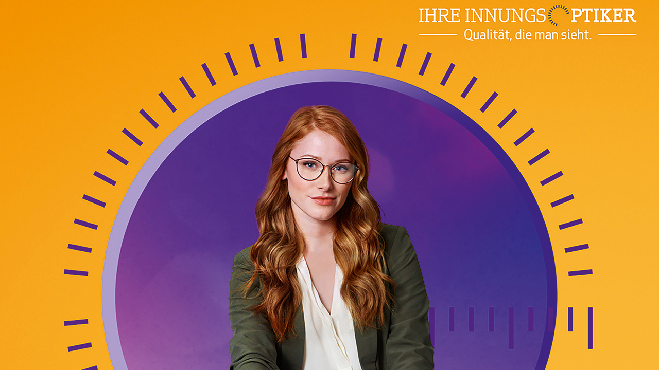 junge Frau mit Brille und rötlichem langen Haar vor lila Hintergrund. 