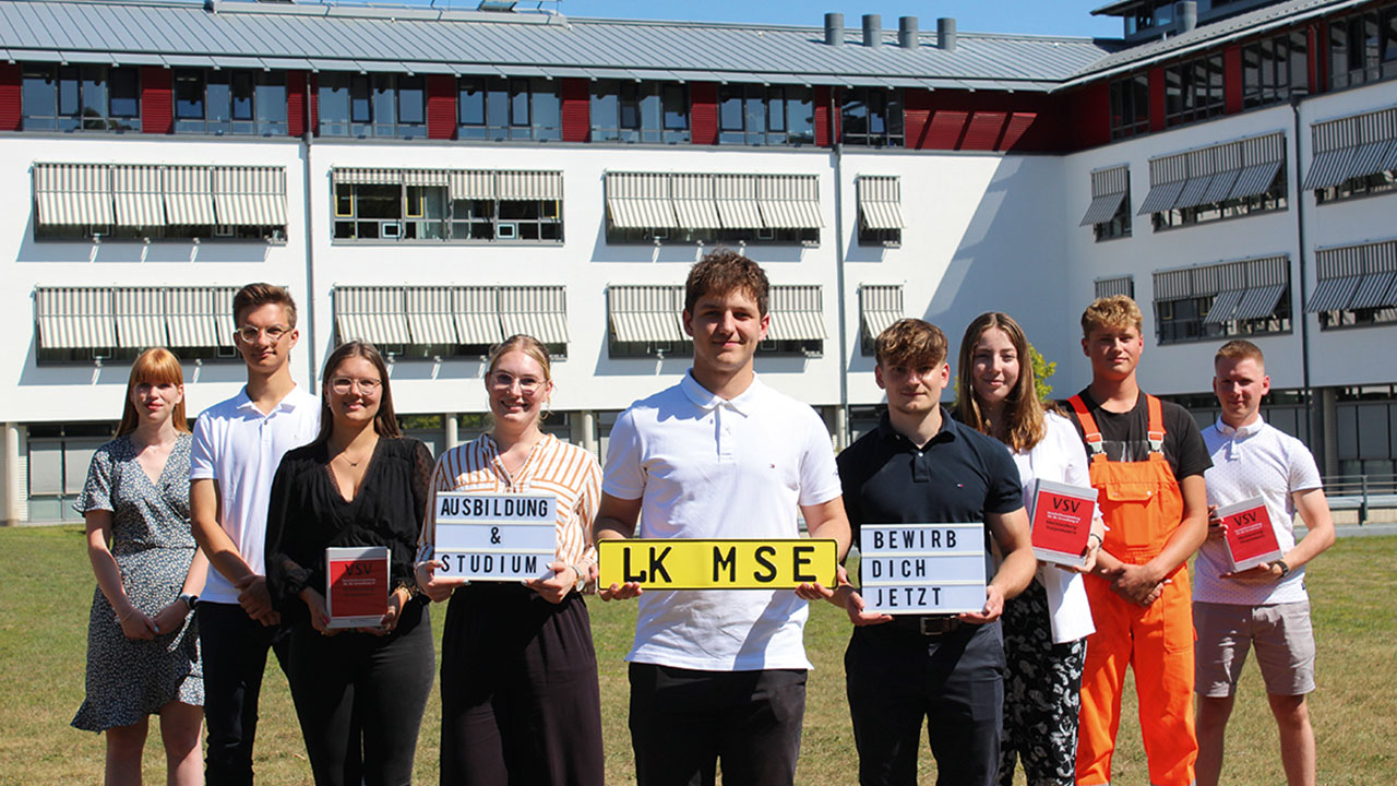 Personen halten verschiedene Schilder hoch.