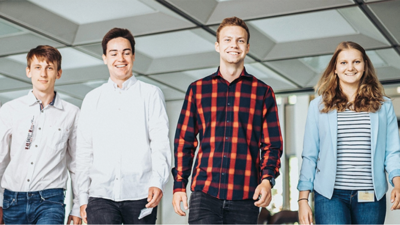 Vier junge Menschen, die freundlich lächeln