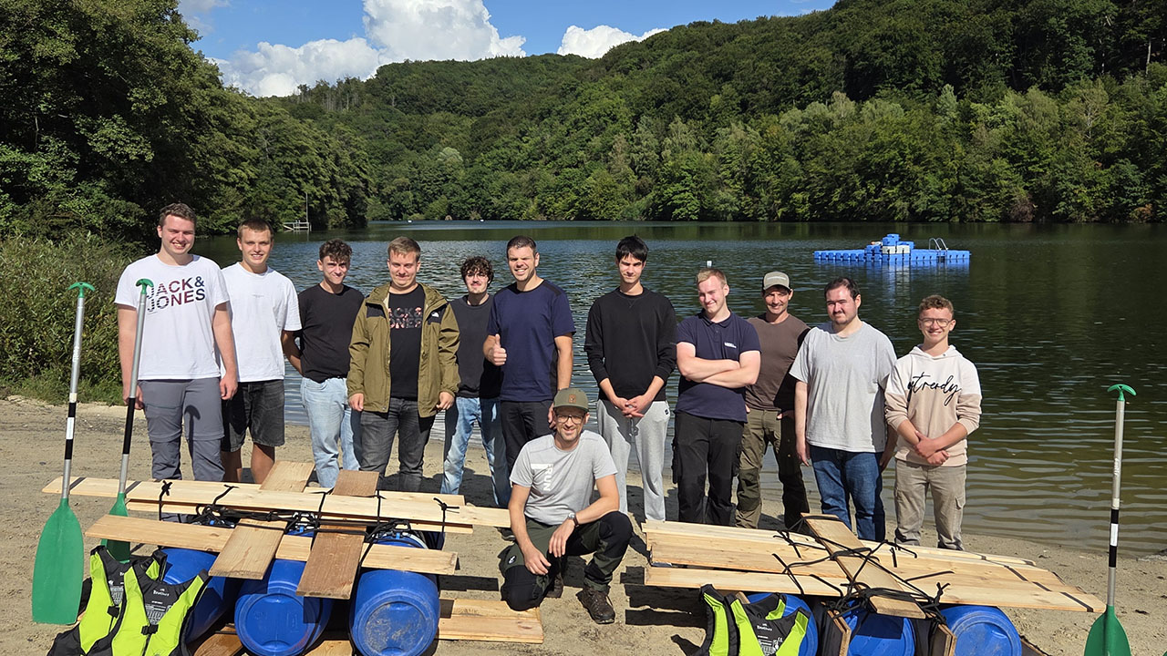 Bild zeigt eine Personengruppe an einem See. Das Bild entstand am Kennlerntag für neue Azubis 2025.
