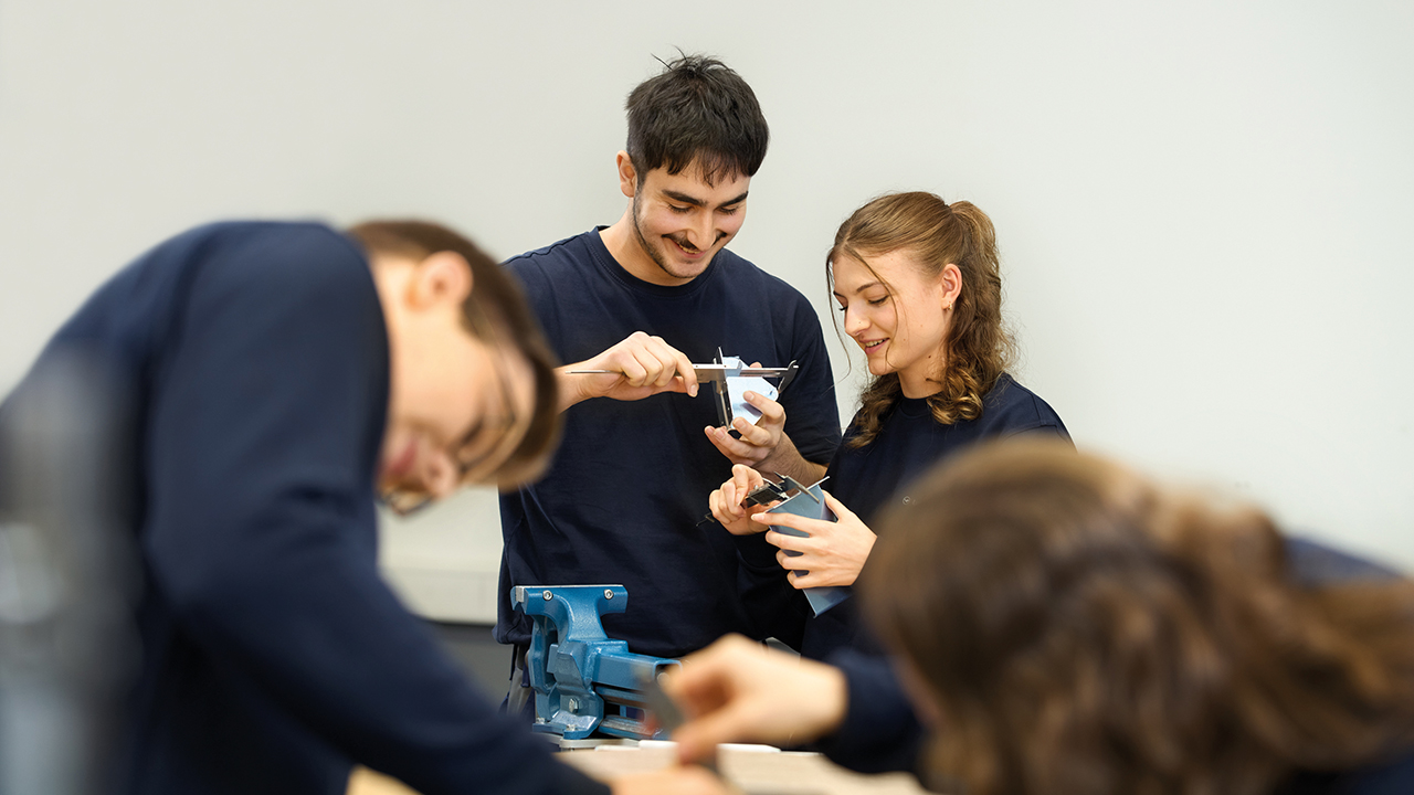 Gruppe junger Menschen bei der Arbeit an Geräten