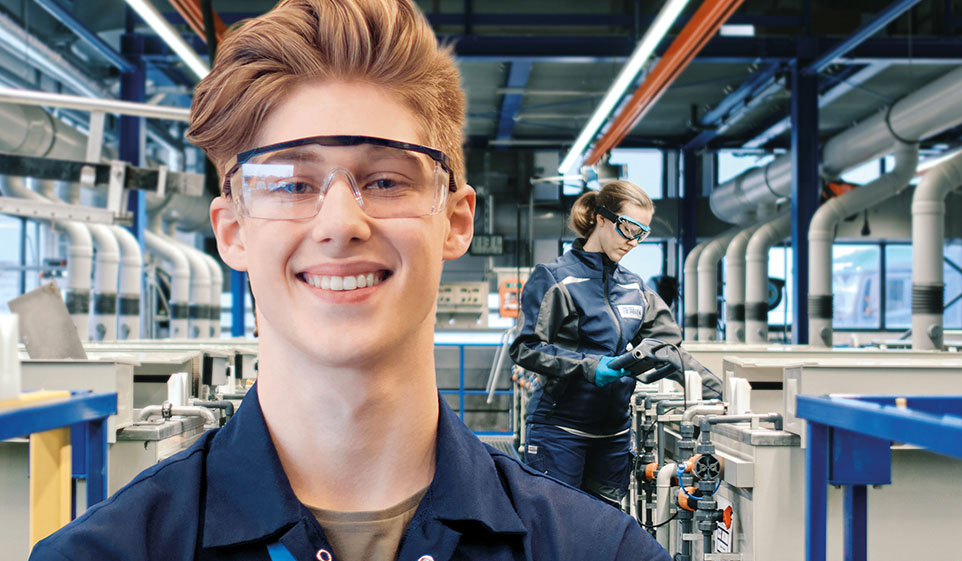 Azubi mit Schutzbrille in Fabrik