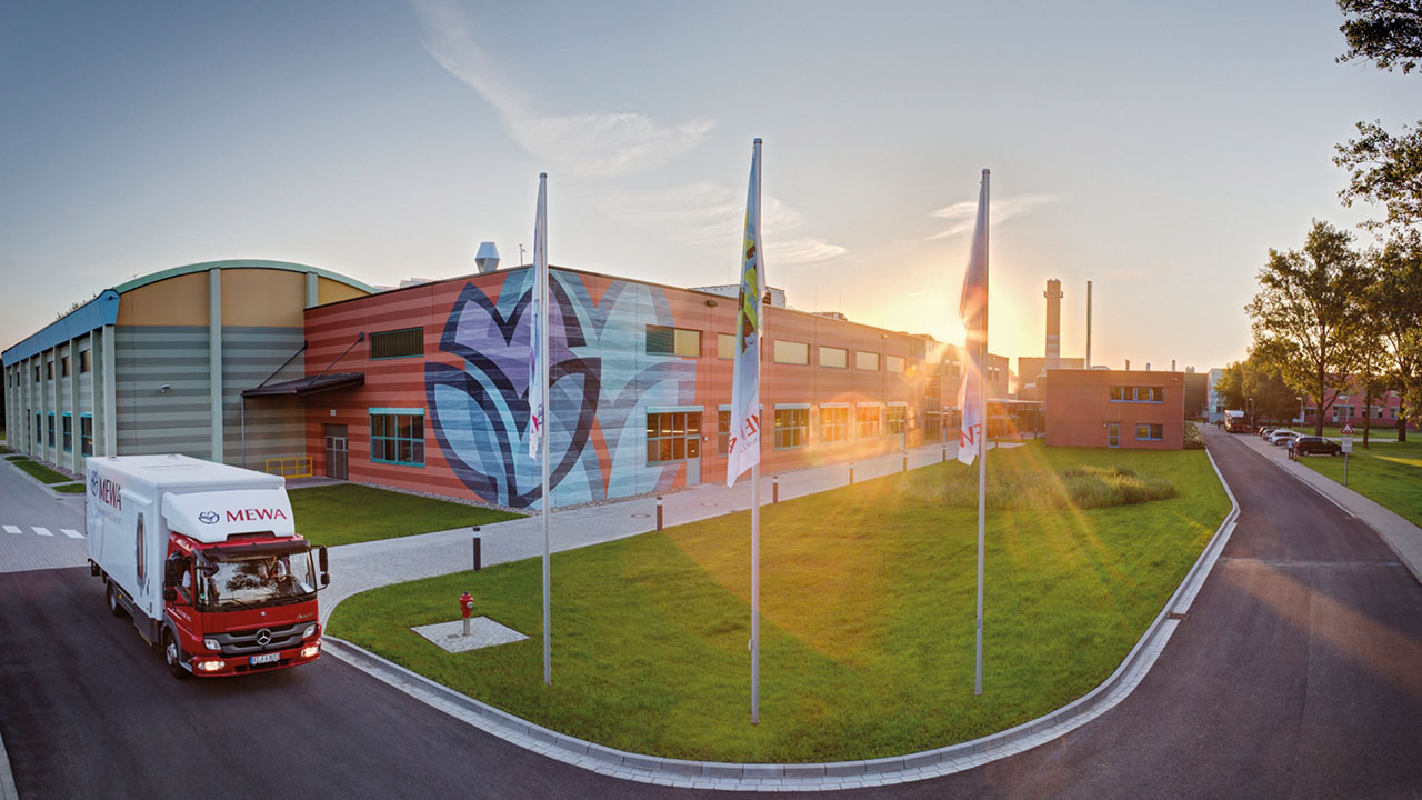 Firmengebäude mit LKW davor und Fahnenstangen