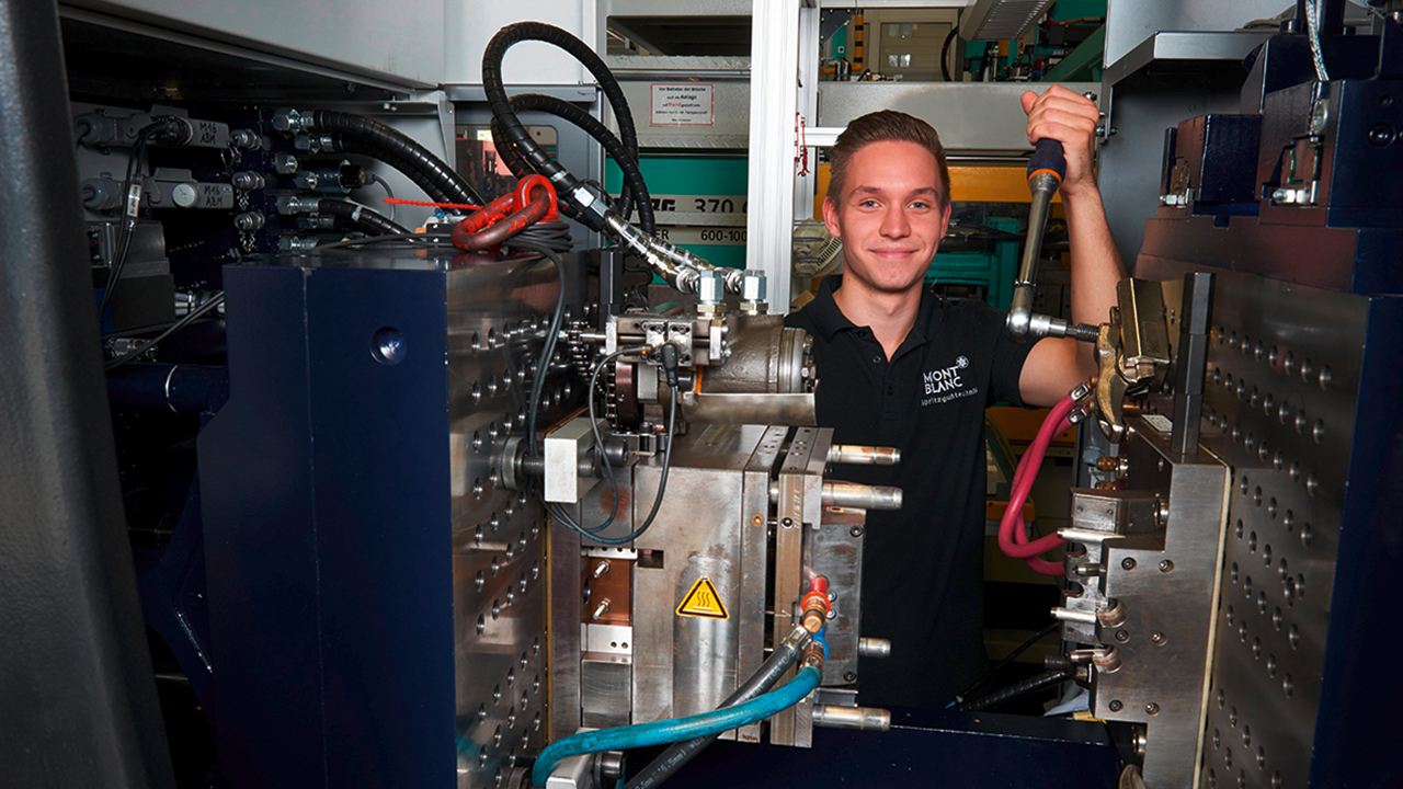 Junger Mann bei der Arbeit an einer technischen Maschine.