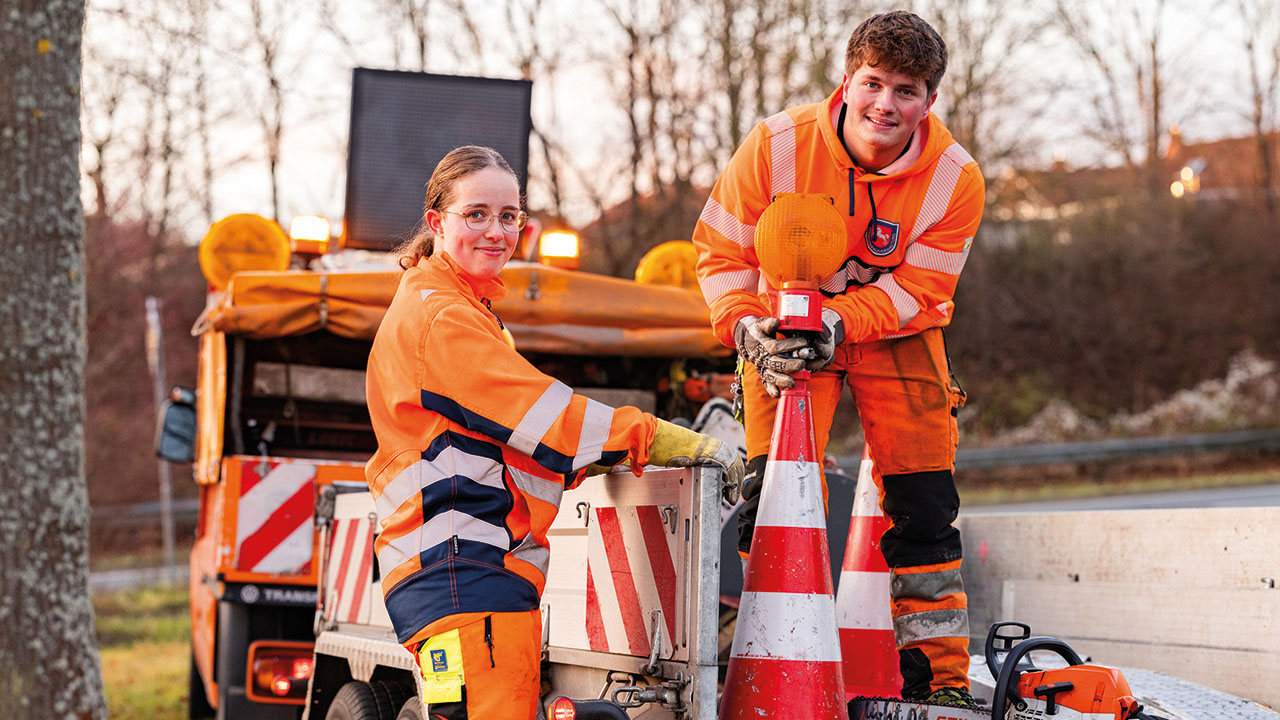 Zwei Straßenwärter (m/w/d) in Arbeitskleidung bei der Arbeit
