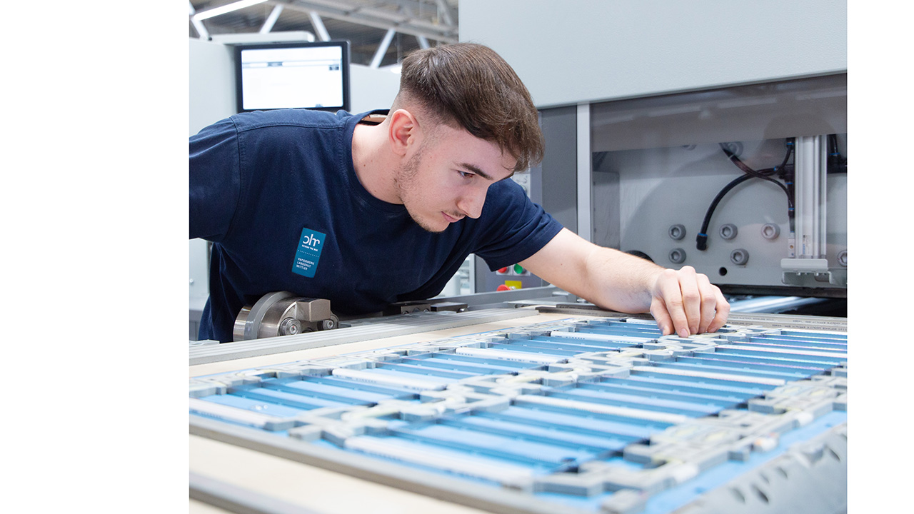 Junger Mensch in der Produktion schaut sich das Papier ganz genau an