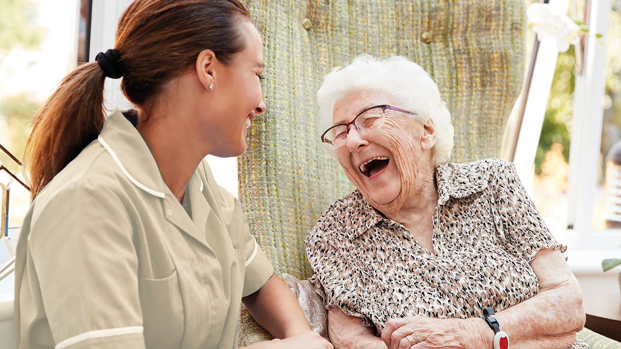 Eine herzhaft lachende Oma mit einer Pflegefachfrau