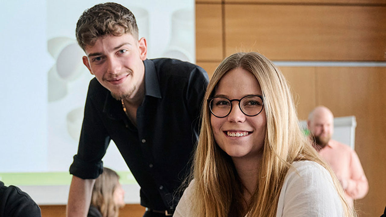 Zwei junge Menschen lächeln in die Kamera