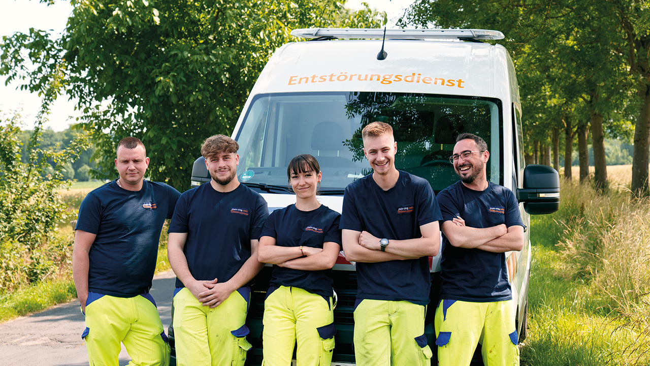 Team in Arbeitskleidung vor einem Einsatzwagen