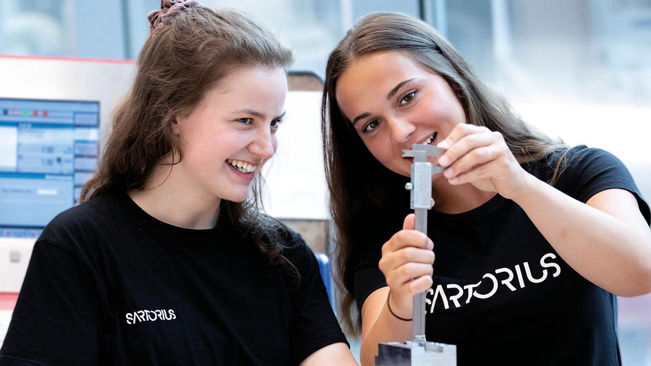 Zwei junge lächelnde Personen in der Werkstatt