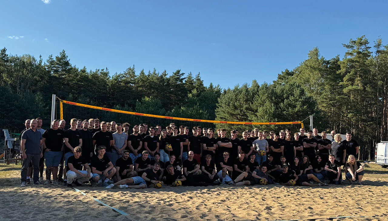 Großes Mannschaftsbild auf einem Beachvolleyball-Feld