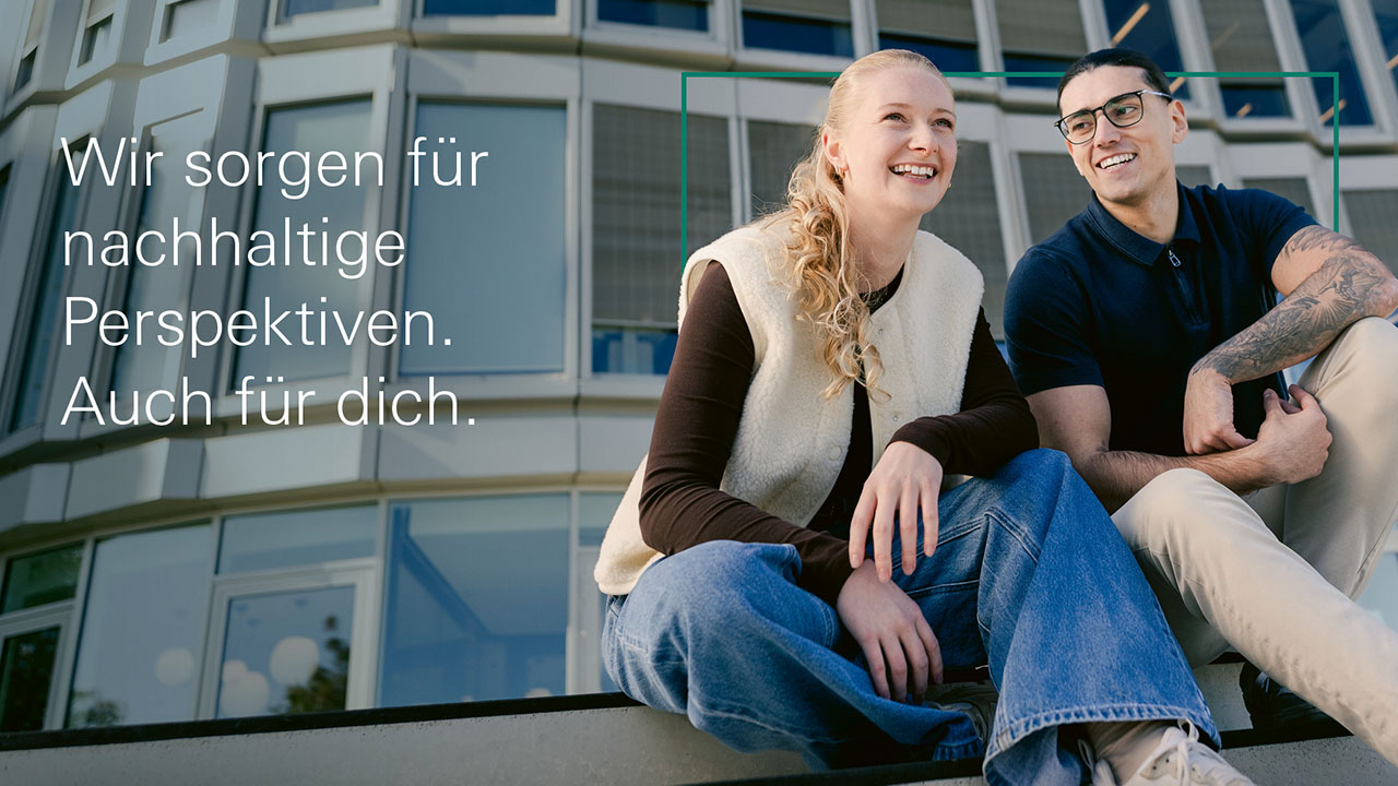 Auf dem Bild sind zwei Personen zu sehen. Sie sitzen auf einer Treppe und lächeln im Hintergrund sieht man ein Gebäude mit einer Glasfront. Linksseitig steht der Slogan "Wir sorgen für nachhaltige Perspektiven. Auch für dich."