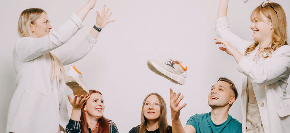 Fünf Personen werfen sich Schuhe zu.