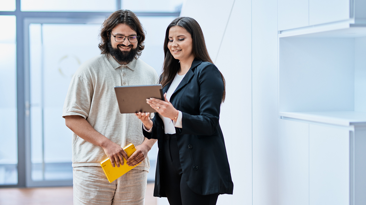 Zwei Menschen schauen sich gemeinsam etwas auf einem Tablet an