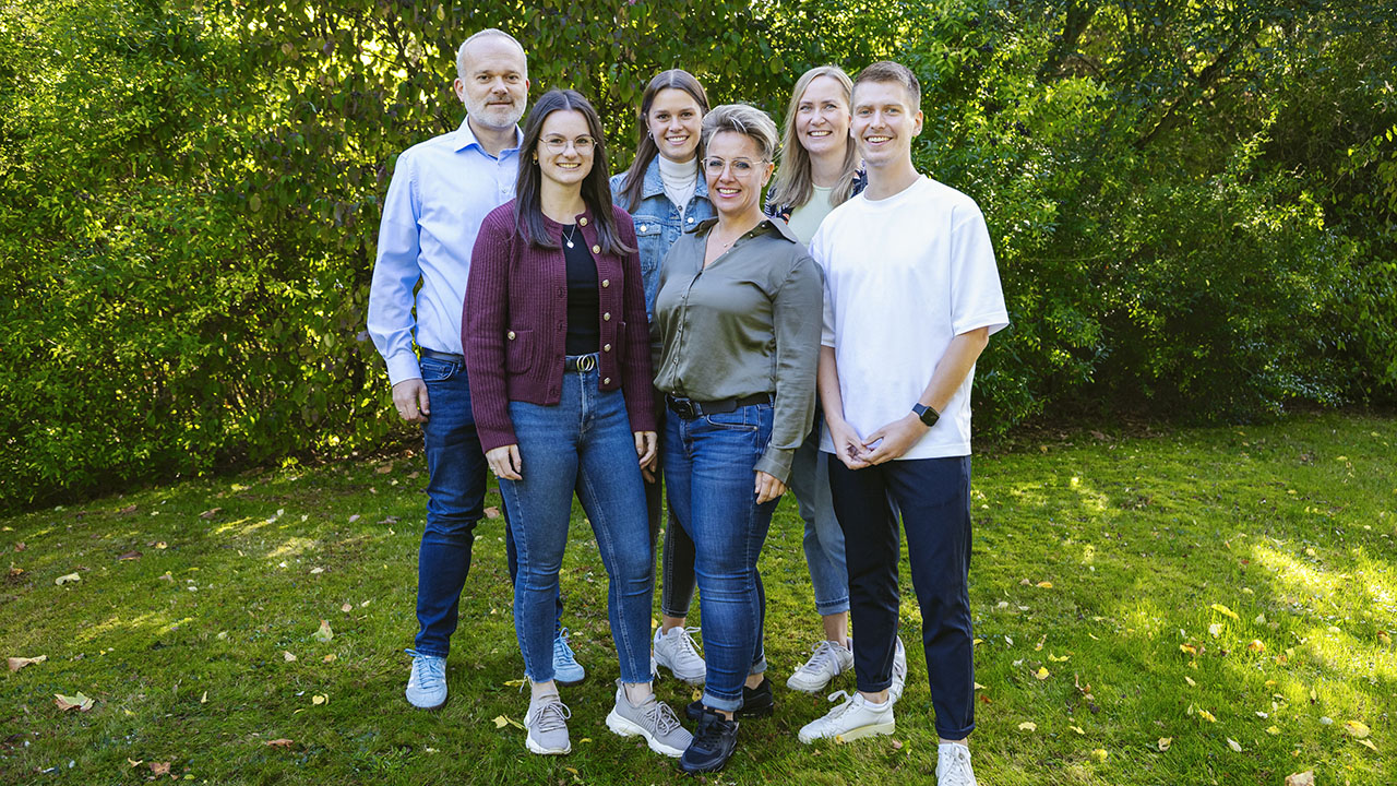 Sechs Mitarbeitende der Stadt Hamm stehen im Grünen und lächeln in die Kamera