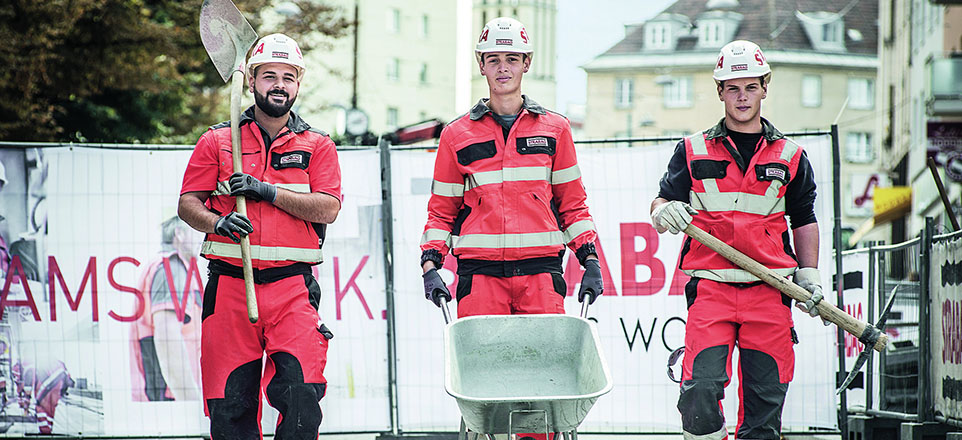Drei Personen in Arbeitskleidung der STRABAG AG.