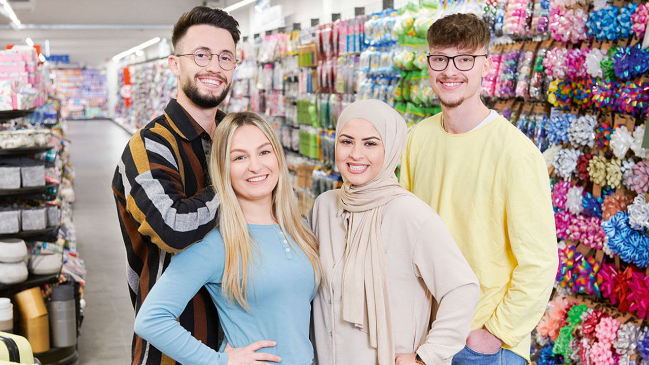 Vier junge lächelnde Menschen in der TEDi-Filiale