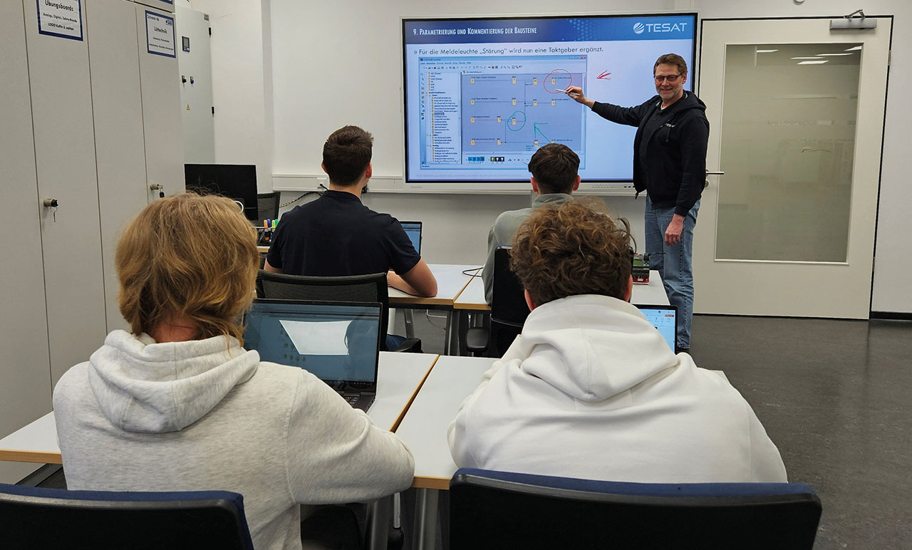 Lehrer erklärt seinen Schülern etwas in einem Schulungsraum.