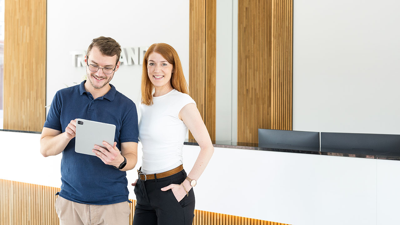 Menschen im Gebäude mit Treuhand-Schriftzug im Hintergrund